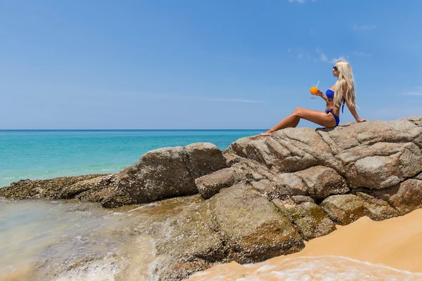 Frau im Bikini mit Orangencocktail am Strand — Stockfoto