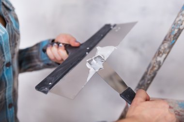 ev geliştirme işçisi kadın tarafından alçı duvara koyar.