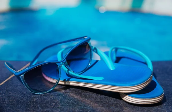 Blaue Hausschuhe und Sonnenbrille beim Schwimmbad-Urlaubskonzept — Stockfoto