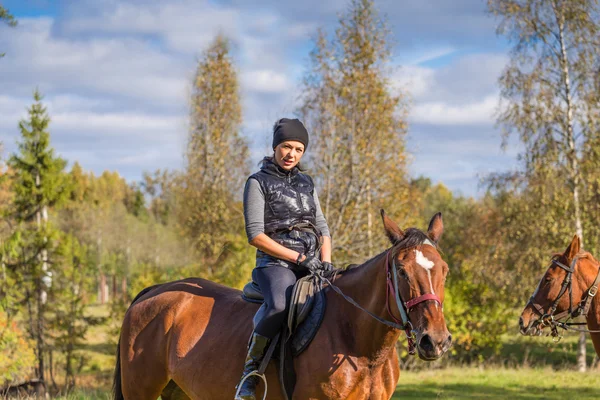 Elegante attraktive Frau reitet auf einer Pferdewiese — Stockfoto