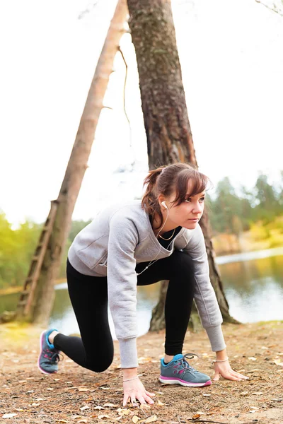 Jovem mulher correr no outono as luzes do pôr do sol da floresta — Fotografia de Stock