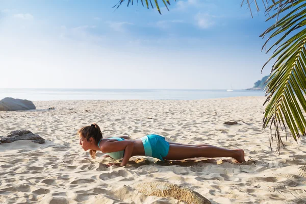 Junge hübsche schlanke brünette Frau üben Yoga-Pose auf tropischen — Stockfoto