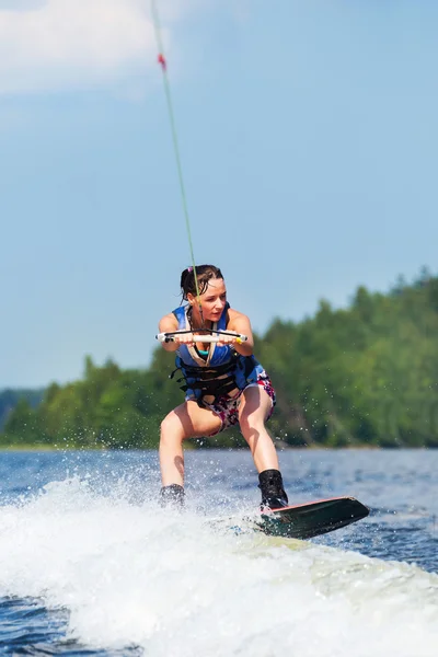 Slanke brunette vrouw rijden wakeboard op motorboot Golf in lake — Stockfoto