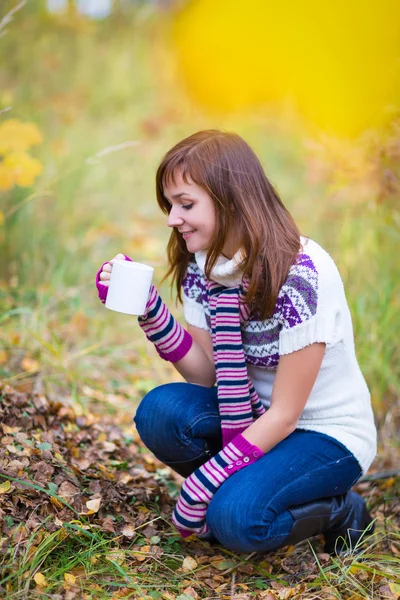 Mujer bonita en un parque de otoño con copa —  Fotos de Stock