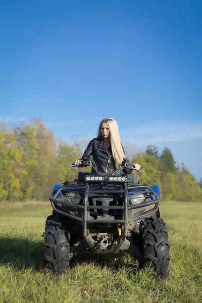 Elegant blonde woman riding extreme quadrocycle ATV on summer fi — Stock Photo, Image