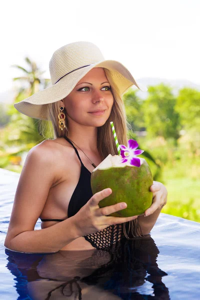 Ung smal blond kvinna hatt drycker friska kokosnöt juice — Stockfoto