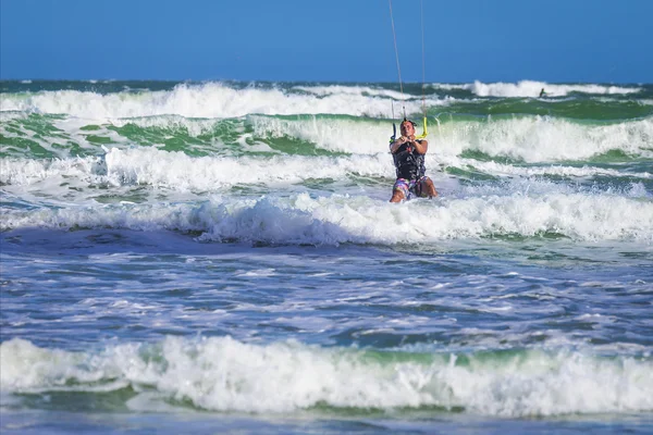 Atletische man rijden op kite surf board in zee golven — Stockfoto