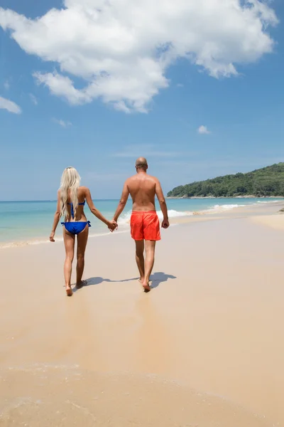 Bonito casal de mãos dadas andando na praia trópica de verão — Fotografia de Stock