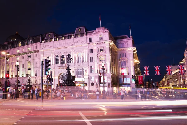 Egyesült Királyság, Anglia, London-2016 június 17: népszerű turista Picadilly cirkusz zászlókkal Union Jack éjszakai fények megvilágítás — Stock Fotó