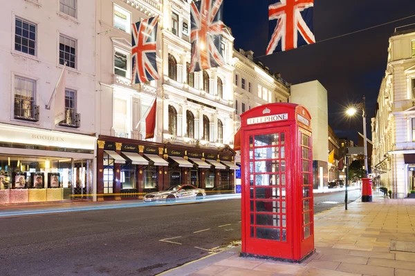 United Kingdom, England, London - 2016 June 17: Popular tourist Red phone booth with flags union jack in night lights illumination — Stock Photo, Image