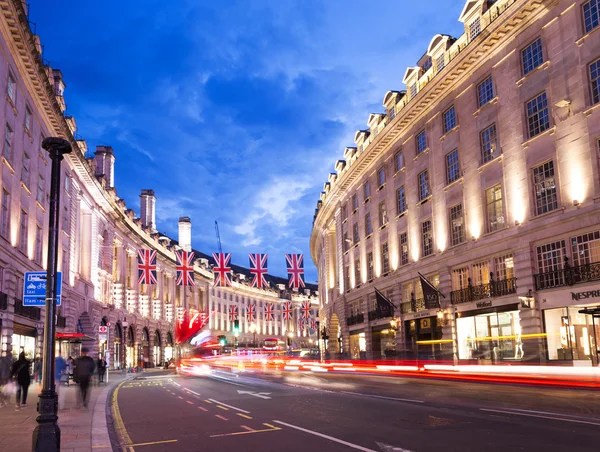 Reino Unido, Inglaterra, Londres - 2016 17 de junio: Popular calle Regent turístico con banderas jack unión en la iluminación de luces de noche — Foto de Stock