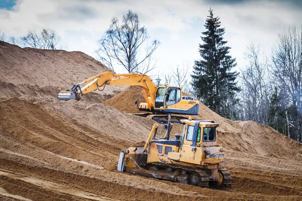 Gelber Bagger und Planierraupe bei der Arbeit im Wald — Stockfoto