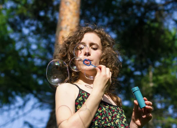 Young pretty woman blowing soap bubbles — Stock Photo, Image