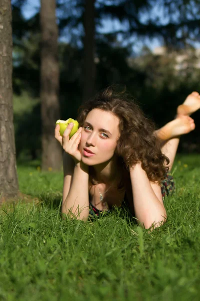 Vacker ung kvinna äta äpple utomhus — Stockfoto