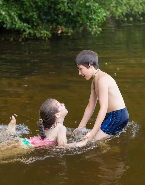 Little boy teaches his little sister to swim — Stock Photo, Image