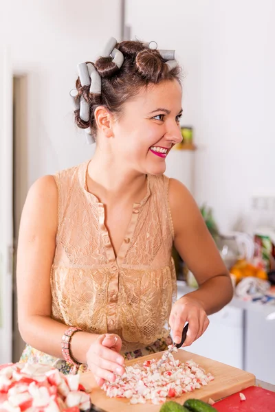 Junge hübsche Hausfrau kocht mit Lockenwicklern auf Haaren — Stockfoto