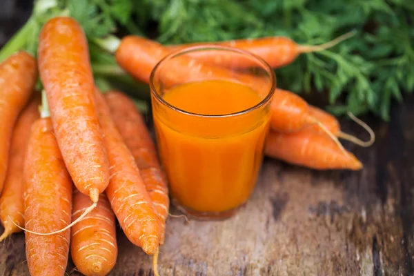 Carrot juice on wooden background — Stock Photo, Image