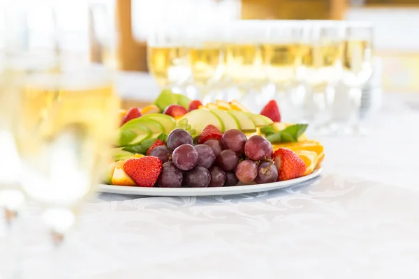 Feestzaal vruchten plaat met champagneglazen — Stockfoto