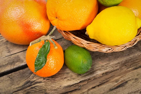 Citrus fruits on wooden background — Stock Photo, Image