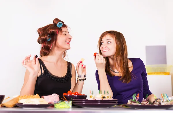 Två unga vackra kvinnan hemmafru matlagning med papiljotter hår — Stockfoto