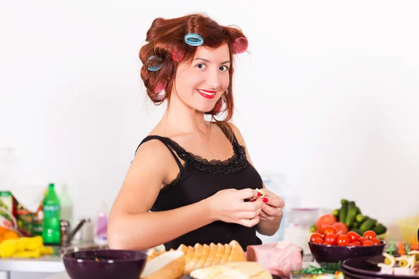 年轻漂亮的女人家庭主妇烹饪用睫毛夹头发 — 图库照片