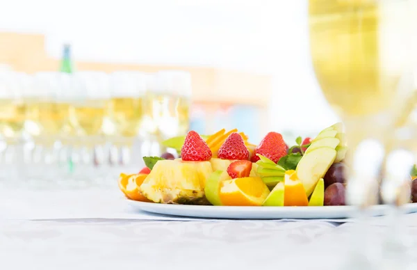 Piatto di frutta banchetto con bicchieri di champagne — Foto Stock