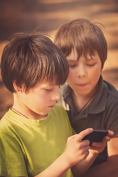 Enfant jouant téléphone mobile à l'extérieur — Photo