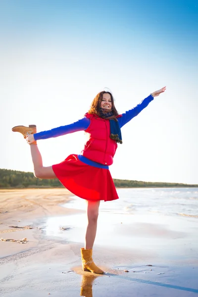 Mujer de rojo divertirse en el costo del lago —  Fotos de Stock