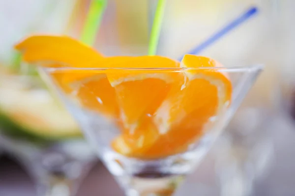 Pomarańczowe owoce ścina w szampan szkło — Zdjęcie stockowe