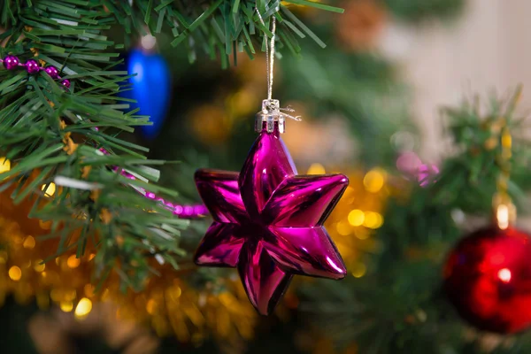 Bola de Natal de estrela roxa em uma árvore — Fotografia de Stock