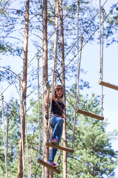 Jonge dappere vrouw klimmen in een touw avonturenpark — Stockfoto