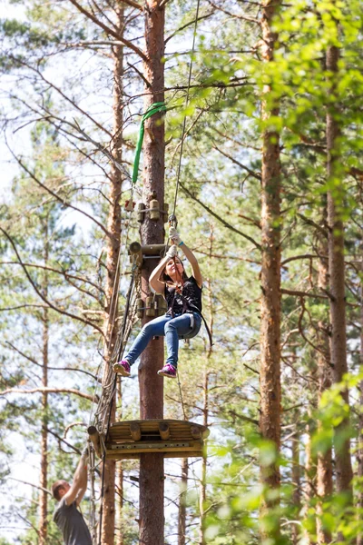 Jonge dappere vrouw klimmen in een touw avonturenpark — Stockfoto