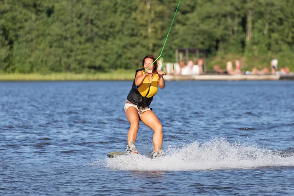 Genç kadın çalışma Wakeboarding bir gölde sürme