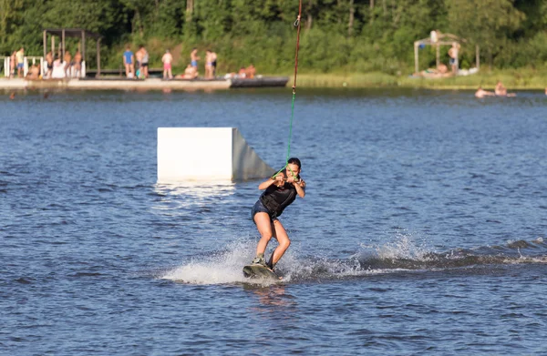 年轻女子骑在湖上滑水的研究 — 图库照片
