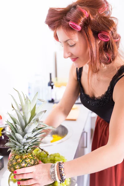 Saç bigudiyle yemek yapan genç ve güzel bir ev hanımı. — Stok fotoğraf