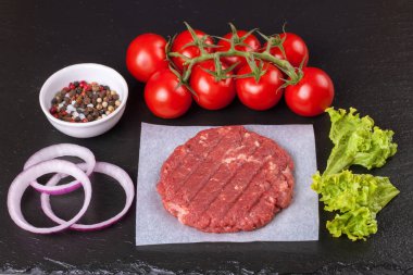Ev yapımı hamburgerin hammaddeleri siyah kaplama arka planda. Üst görünüm.