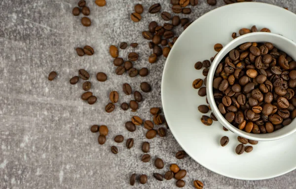 Xícara de café com grãos torrados no fundo cinza pedra. — Fotografia de Stock