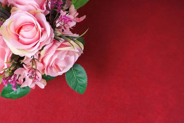 Roze roos boeket en rood hart op rode achtergrond. — Stockfoto