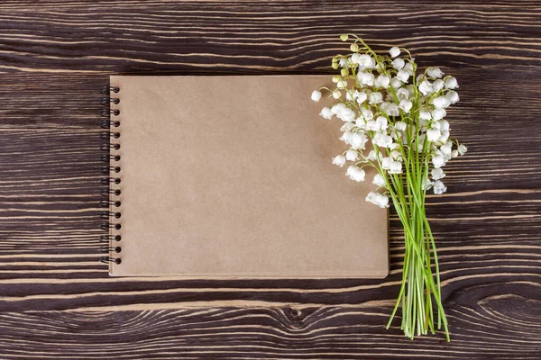 Kytice Květin Lilie Údolí Prázdný Papírový Zápisník Hnědém Dřevěném Rustikálním — Stock fotografie
