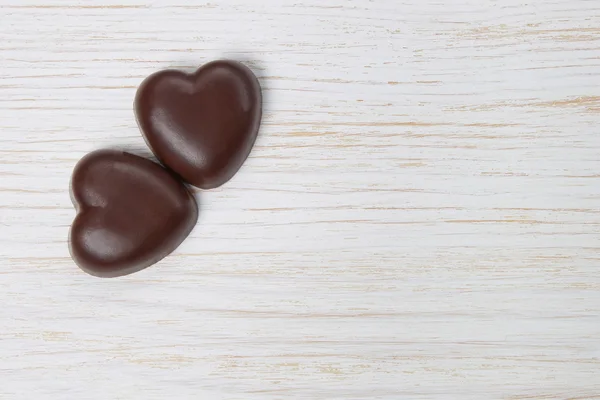 Chocolate candy hearts on a wooden background — Stock Photo, Image