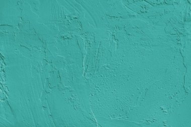 Yaklaş, turkuaz boyalı, sert sıva ve beton yüzey dokusuyla kaplanmış duvar. Soyut arkaplan, tasarım için arkaplan, duvar kağıdı sanatı veya dekorasyon projeleri.
