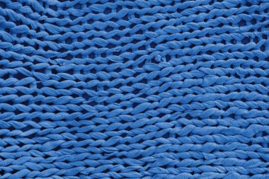 Makro, yakın çekim, detaylı mavi örgü tekstil, kumaş dokusu ve kalın iplik desenli altyüzü. Konforlu el yapımı kumaş arka plan, örgü örtüsü tasarım için mükemmel, el işi, sıcak kış konsepti