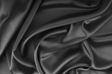 Buruşuk, buruşuk siyah renkli parlak ipek saten ve dalga örtüsü. Yumuşak kıvrımlı, parlak, pürüzsüz kumaş. Zarif zengin bir zemin, duvar kâğıdı, fon. Düz yatış, üst görünüm