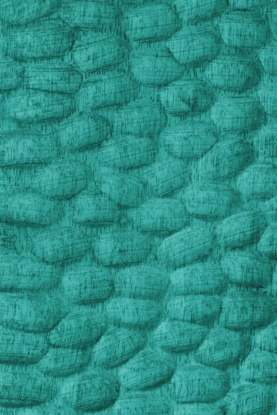 Oyulmuş oval desenleri ve ahşap tahılları olan desenli turkuaz renkli ahşap yüzey. Tasarım, zanaat veya doğal doku ve materyal temaları için soyut doku arka planı ideali.