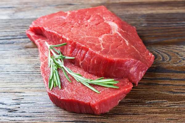 Färsk rå kött med rosmarin — Stockfoto