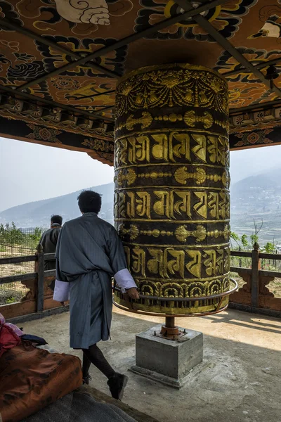 Pèlerin bouddhiste priant avec une roue de prière au monastère de Chimi Lhakang, au Bhoutan — Photo