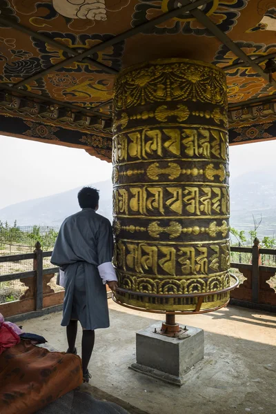 Pèlerin bouddhiste priant avec une roue de prière au monastère de Chimi Lhakang, au Bhoutan — Photo