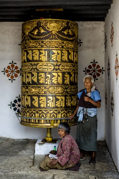 Pielgrzym buddyjskich, modląc się z koła modlitwy w Chimi Lhakang klasztor, Phunakha, Bhutan — Zdjęcie stockowe