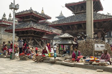 Katmandu, Nepal - 13 Nisan 2016: Kuru mısır kuş beslemek hasarlı Katmandu Durbar Meydanı olarak büyük depremden sonra 2015 yılında satış kimliği belirsiz kadın.
