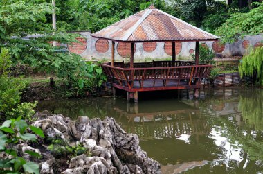 Göletin yanındaki eski kulübede, göletin kıyısındaki küçük ahşap kulübede..